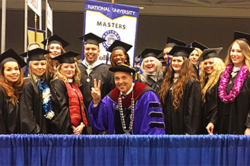 Chancellor Cunningham poses with a group of NU graduates
