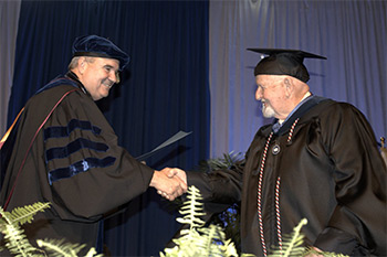  President Andrews congratulates graduates as they receive their diplomas in 2017.