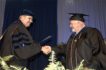 President Andrews congratulates graduates as they receive their diplomas in 2017.
