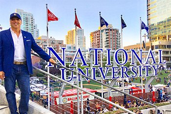 Chancellor Cunningham in front of the National University sign at Petco Park in San Diego, CA.