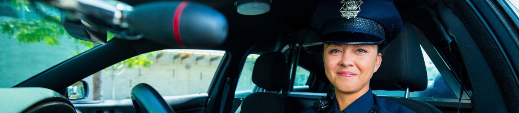  woman police officer sits in a patrol car