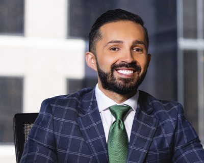 man in a plaid suit sits at a desk in an office