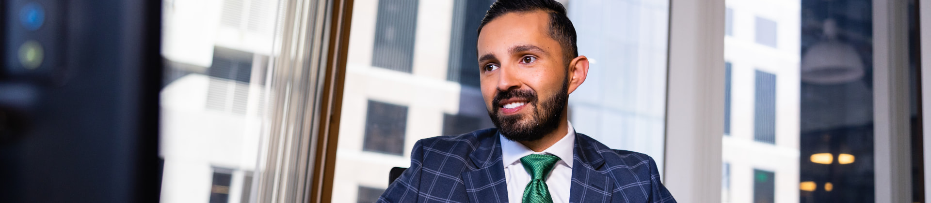 Man in suit looks ahead of him in a conference room