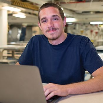 a man works on a laptop in an open office