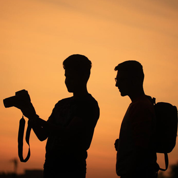 two men look at a camera to review a shot