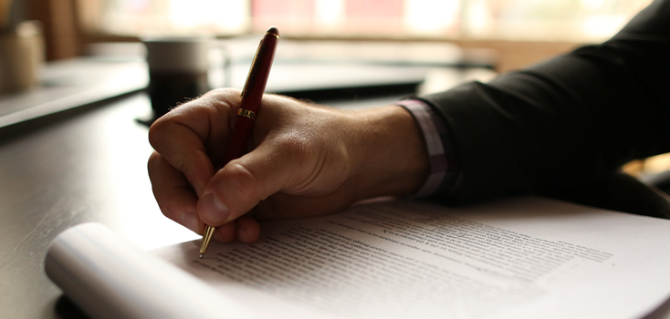 closeup of a person making notes on a printed report