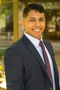 man in a suit smiles at the camera