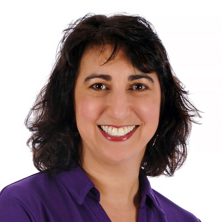 Dr. Dawn Tamarkin, a woman with dark brown hair, wearing a purple dress shirt