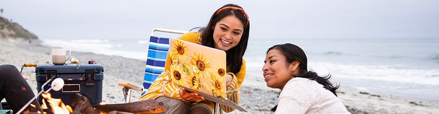 Krystal F. - Class of 2021, at beach with laptop and friend