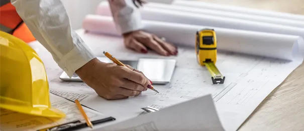 Construction manager reviewing blueprints on job site 