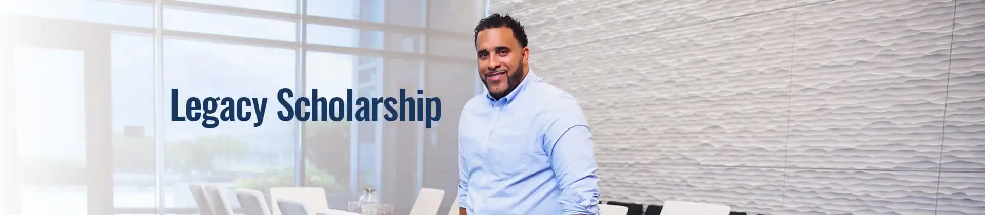 Man in a blue dress shirt stands in an all white conference room