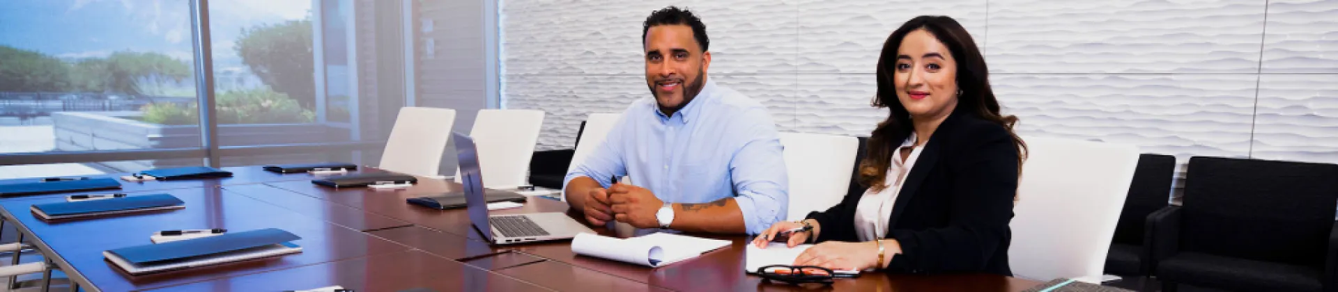 two professionals sit waiting in a board room