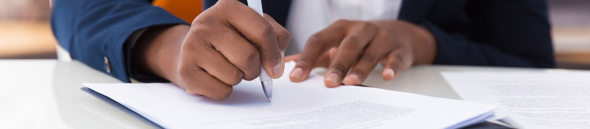 Close up of a man's hands as they write notes on a piece of paper.