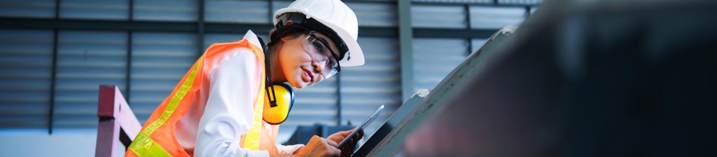 woman works in a hard hat and hi-vis vest