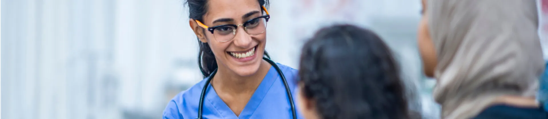 nurse practitioner woman smiling at two female patients