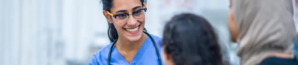 nurse practitioner woman smiling at two female patients