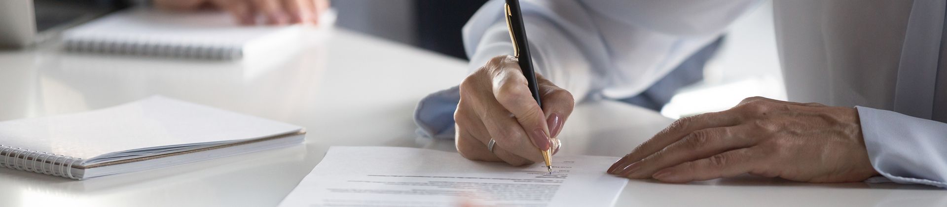 Closeup of woman writing on paper for the Paralegal Specialist Certificate Corporations program