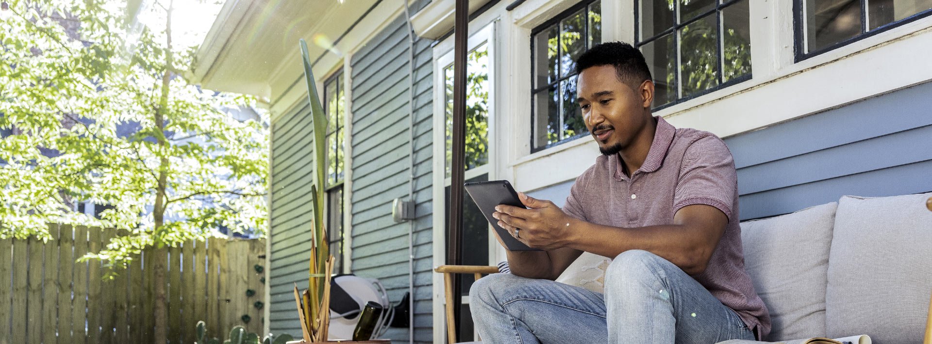 Man reading tablet sitting on porch