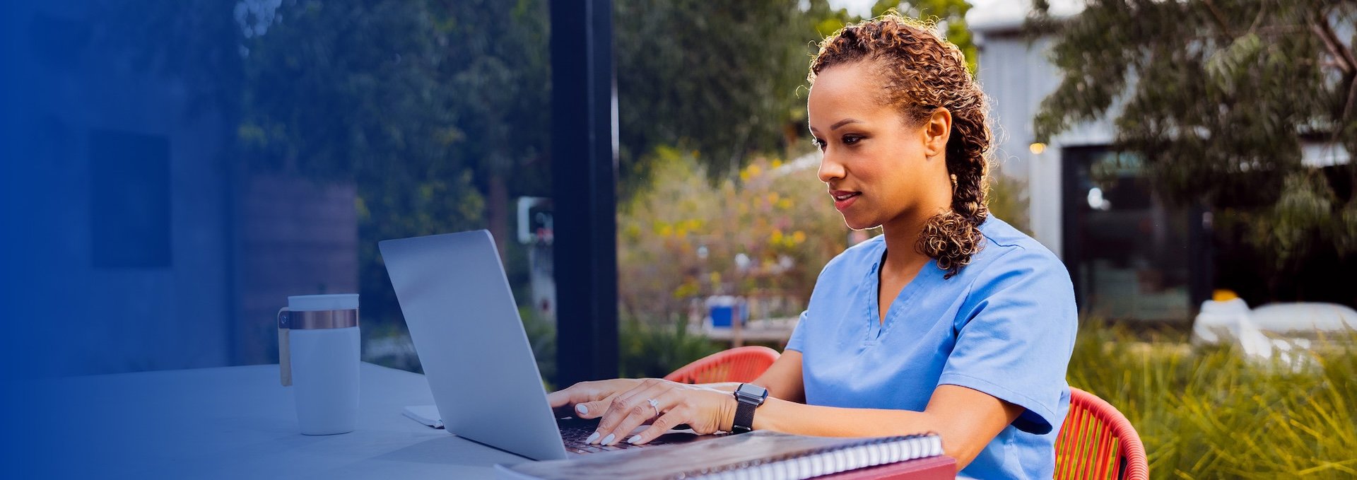 nurse sitting outside working on laptop