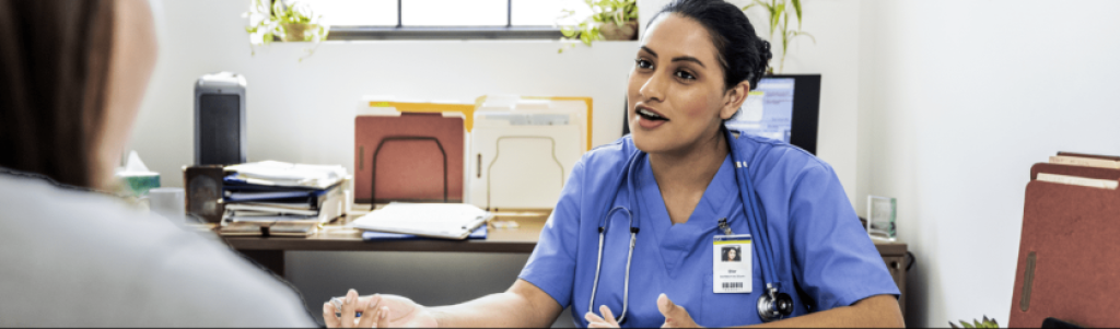 nurse practitioner sitting at desk talking with patient