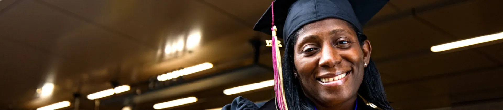 woman smiling with graduation cap on with a Psychology PhD