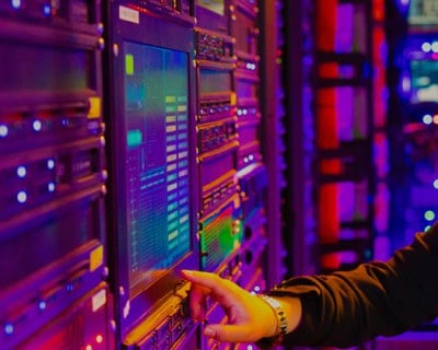 woman in server room pointing at screen