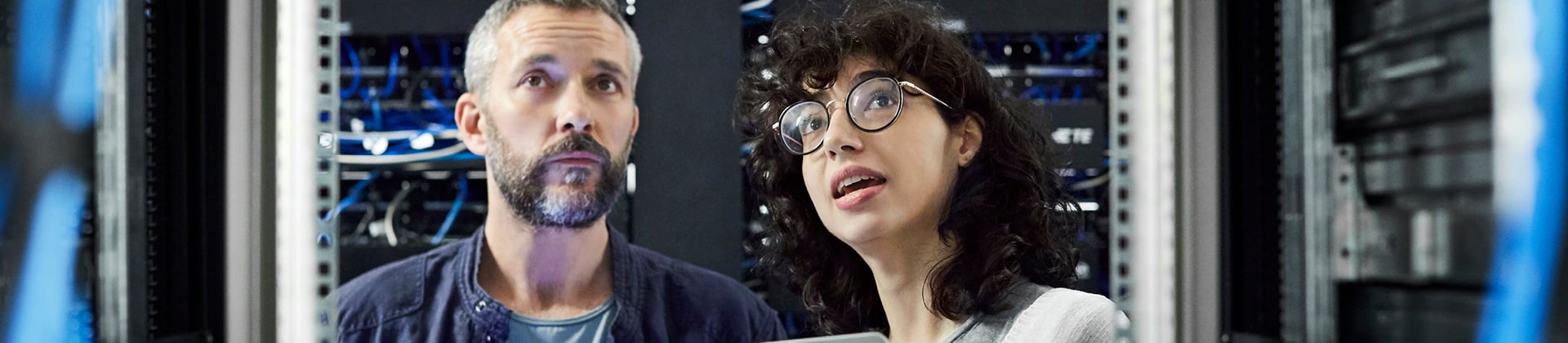 man and woman in server room looking up in awe