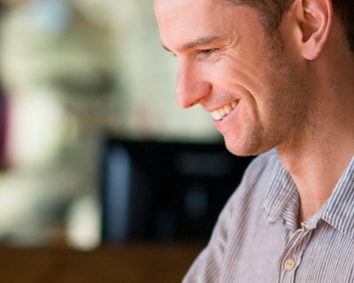 man smiling down at laptop