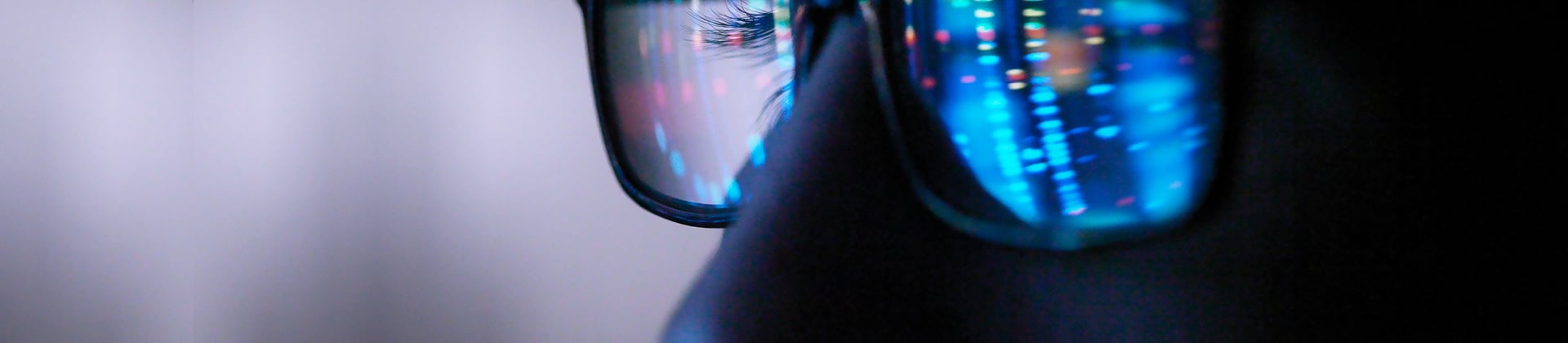 reflection of computer on persons eyeglasses 