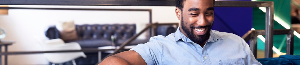 man sitting on couch smiling down