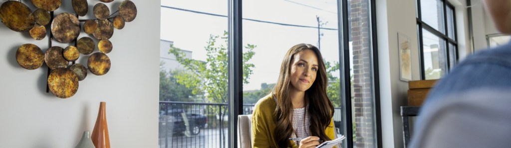woman smiling at man taking notes