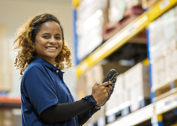 woman in a polo shirt stands in a warehouse