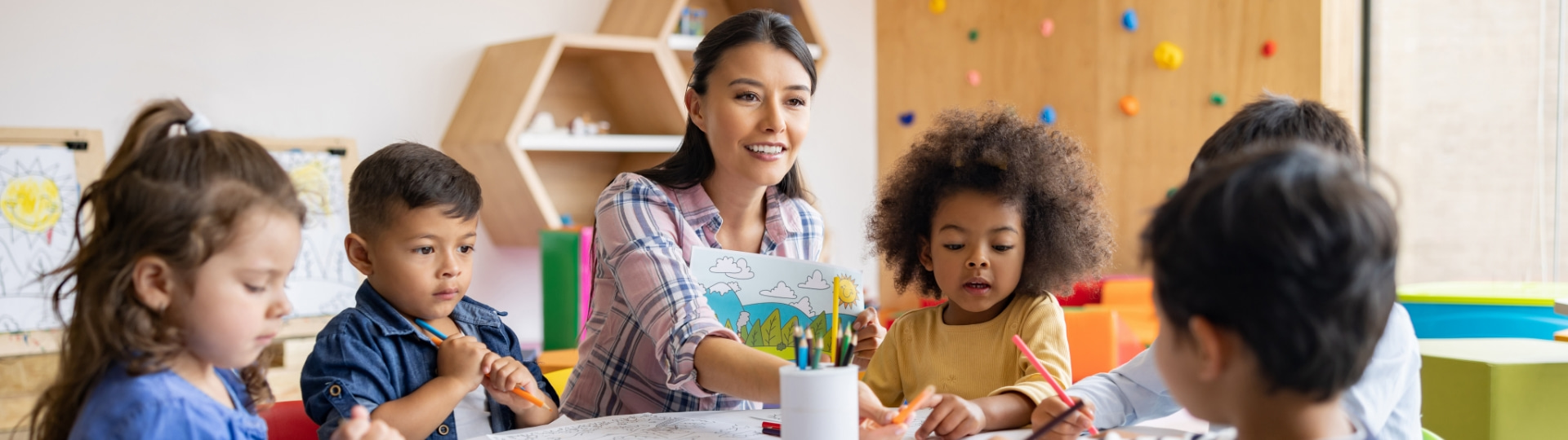 Teacher at table with children coloring