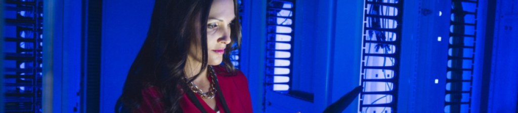 woman in a server room looking at a tablet