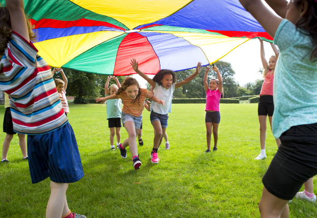 children play outside with parachute fabric