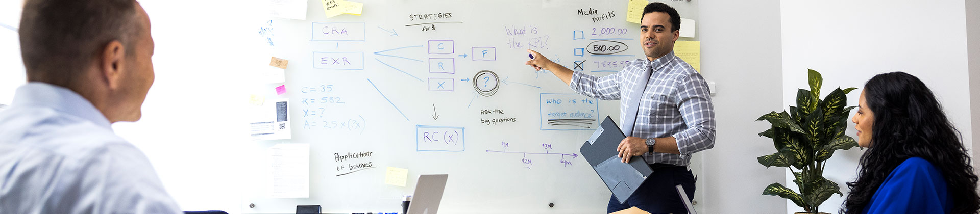 man in a tie teaches on a whiteboard