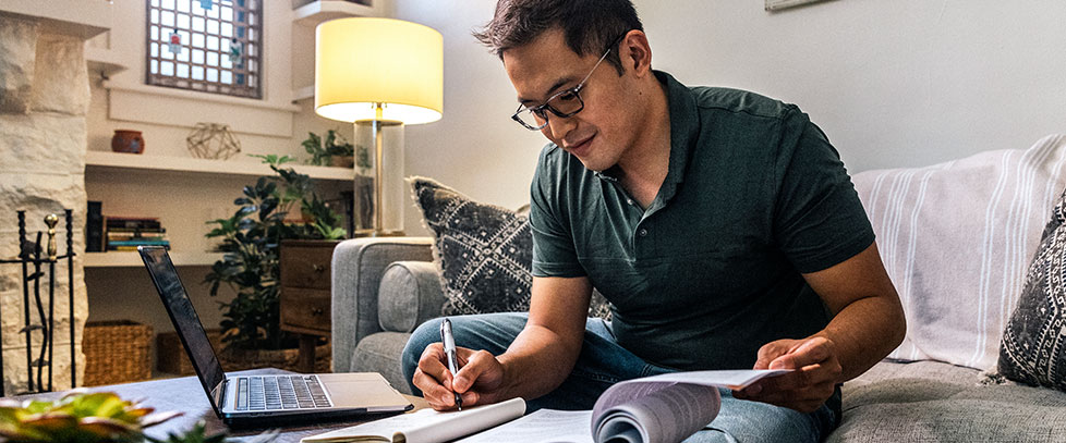 man studies on his couch