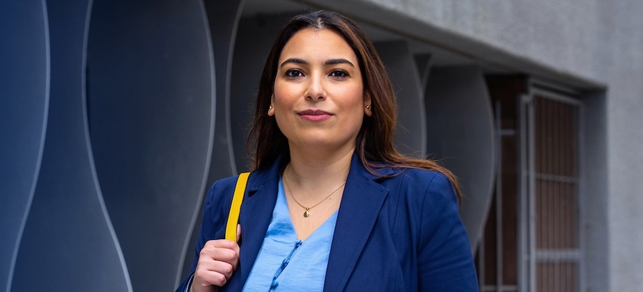 woman in blue sport coat with bag over her shoulder