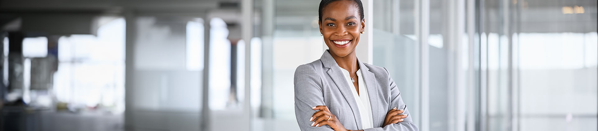 woman in a suit stands with her arms crossed