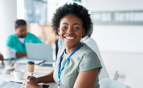 nurse sitting at desk with coffee cup