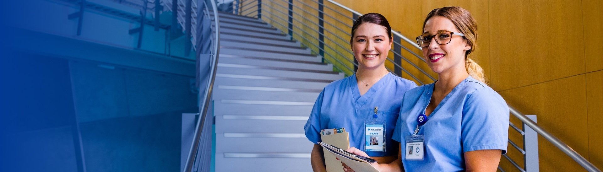 two nurses standing at bottom of stairs