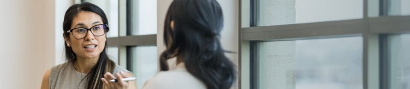 two woman talking in office