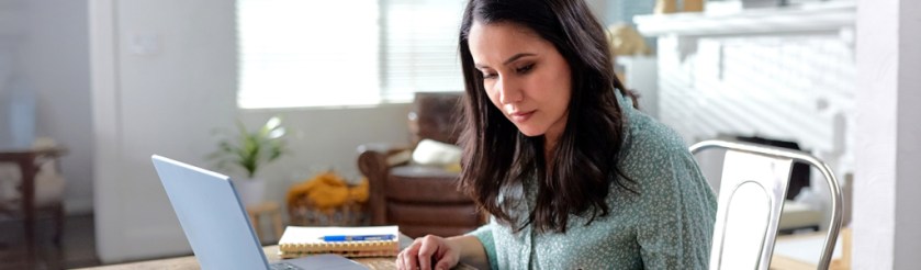 person sitting at table working on laptop