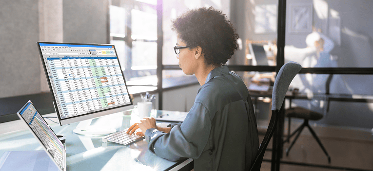 person sitting at desk working on spreadsheet