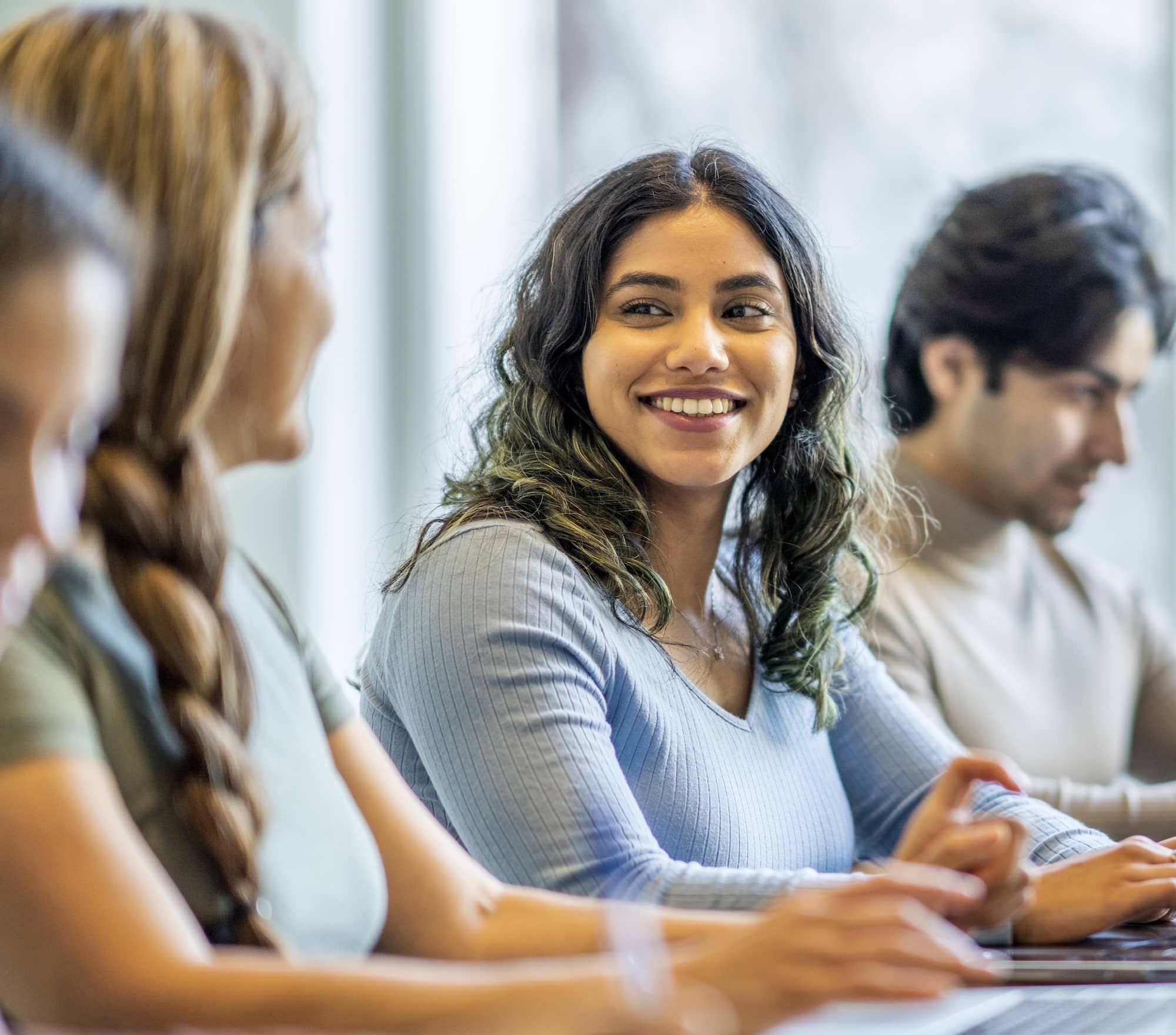 woman working on computer looking at colleagues