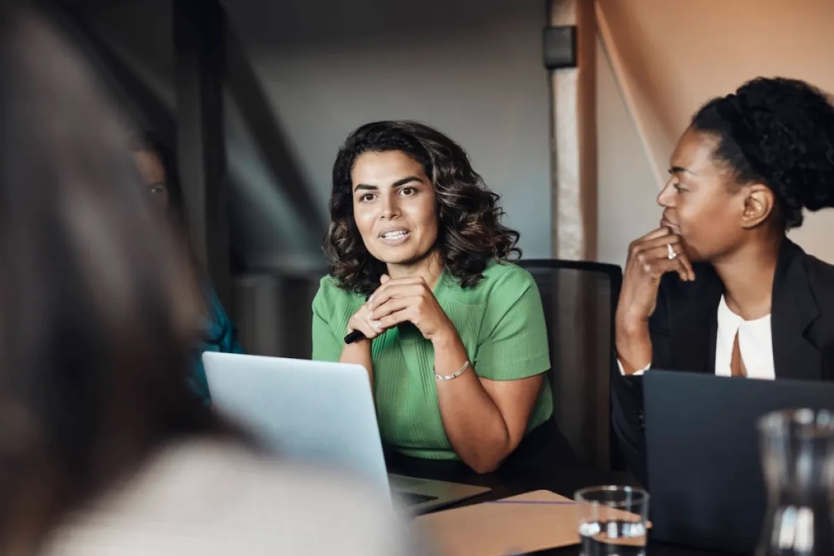 women in a boardroom discussing issues