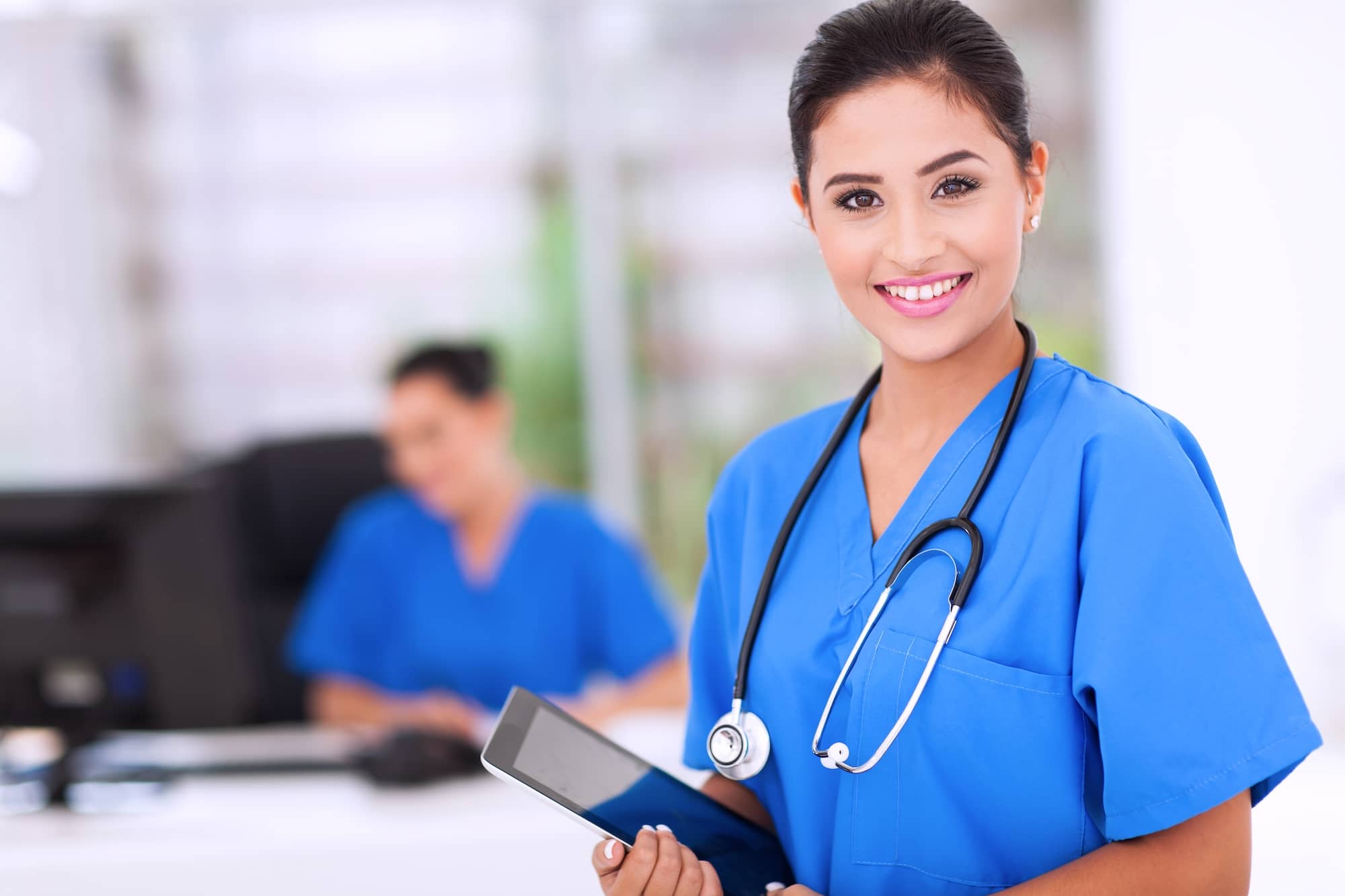 two nurse practitioners in blue scrubs