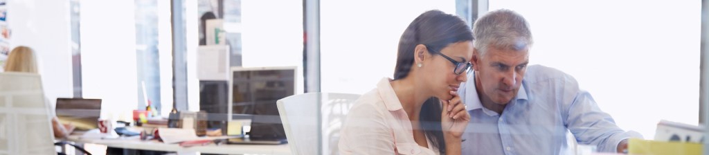 two people look at a screen together in an office