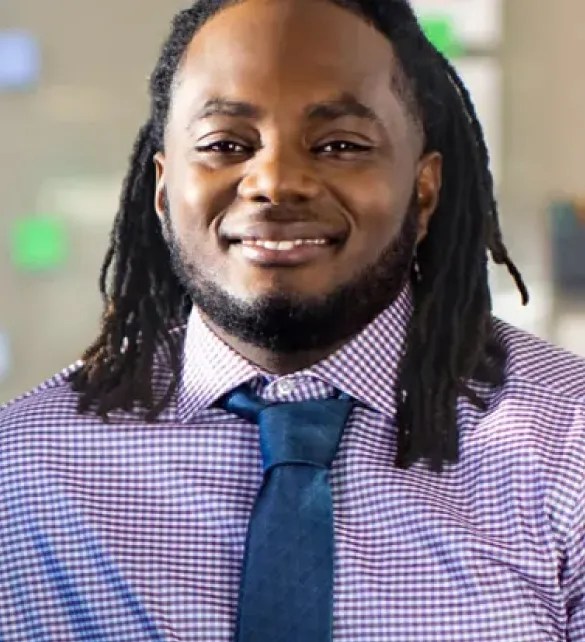 young man smiling wearing oxford shirt and tie