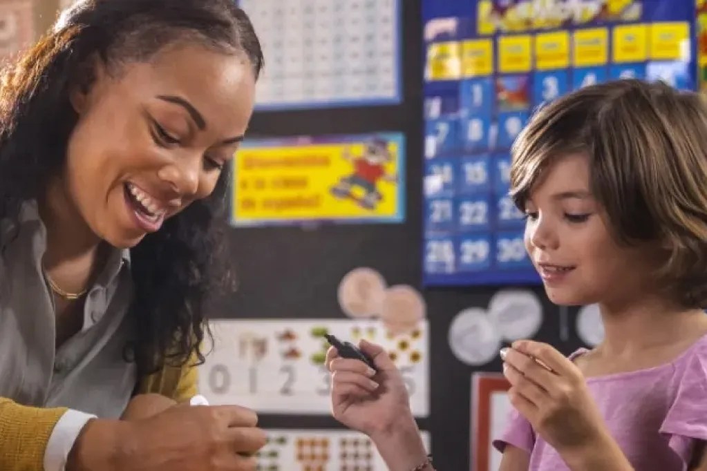 elementary school teacher working with student